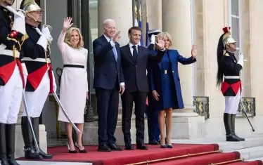 Първите дами на САЩ и на Франция - съответно Джил Байдън (вляво) и Брижит Макрон (вдясно), стоят редом до съпрузите си на входа на Елисейския дворец.