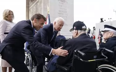 Двамата държавни глави разговарят с френския ветеран от Втората световна война Жак Леви, участвал в десанта на Нормандия заедно с американските войници.