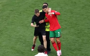 Фен прегръща насила Роналдо през врата, бързайки да се щракне преди доближилия се стюард да го отведе