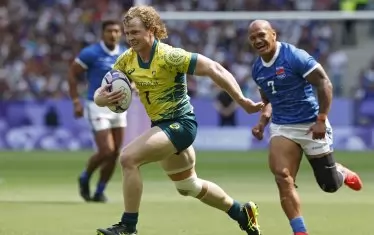 Австралиецът Хенри Хъчисън се откъснал с топката от преследващия го Лаломило Лаломило в опит да отбележи есе срещу Самоа в откриващия мач по ръгби 7 на "Стад дьо Франс" в Париж.