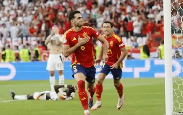 Испанският халф Микел Мерино се тупа по гърдите след победния си гол, докато зад гърба му двама от германските национали не могат да повярват, че тимът им ще отпадне от турнира.