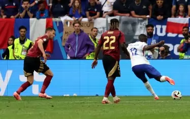 Френският нападател Рандал Коло Муани (вдясно) замахва да нанесе шута, при който топката се удари в белгиеца Ян Вертонген (вляво) и реши изхода на 1/8-финала в Дюселдорф.