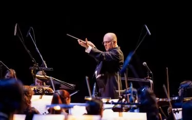  С нов стайлинг на прическата, маестро Найден Тодоров дирижира музиката на един от любимите си композитори.