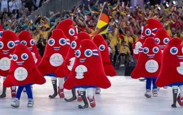  Актьори, преоблечени като фригийски шапки - талисманът на игрите, посрещнаха спортистите