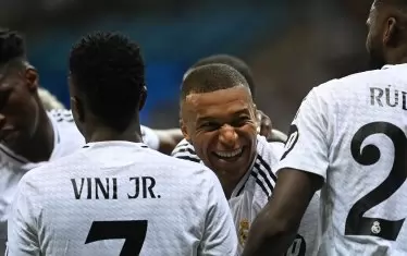 Килиан Мбапе (в средата) се радва на първия си гол за "Реал" (Мадрид), а Винисиус Жуниор (вляво) и Антонио Рюдигер се приближават да го поздравят по време на мача срещу "Аталанта" за Суперкупата на Европа.