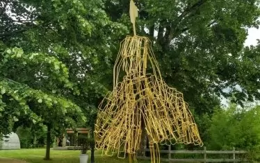   Художникът извайва от метал изяществото на женския силует, облечен в разкошна рокля.