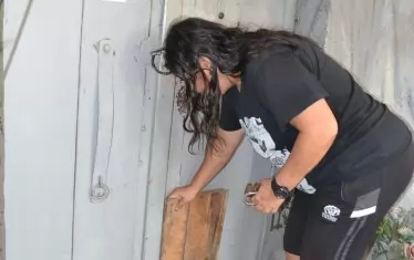  Жена подпира църковната врата с дъска, за да спре течението.