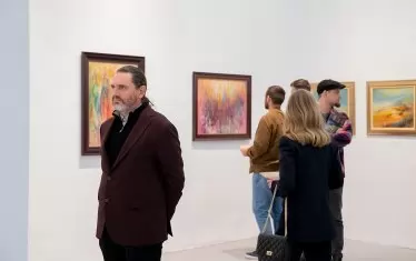  Председателят на СБХ - художникът Любен Генов, разглежда картините.