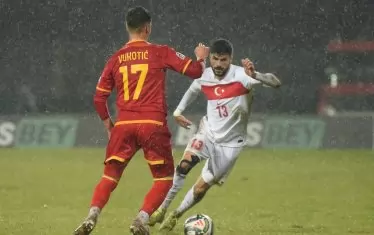 Черногорският халф Милан Вукотич (вляво) се готви да пресрещне левия бек на турците Ерен Елмалъ под проливния дъжд в Никшич.
