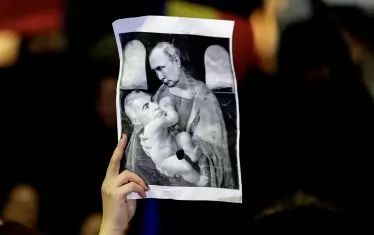 Плакатът показва колаж, изобразяващ Джорджеску като младенеца, който бозае от  Путин