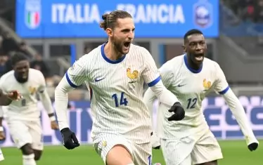 Халфът Адриен Рабио (№14) тича радостно по терена на "Джузепе Меаца" след първия от двата си гола при победата на Франция над Италия.