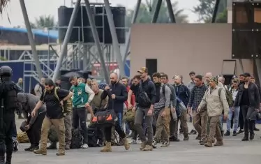 Мъже, за които се смята, че са военни контрактори, чакат на граничния пункт La Corniche между Демократична република Конго и Руанда, преди да преминат в Руанда. 





