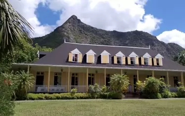  Колониална къща на фона на вулканично възвишение. 