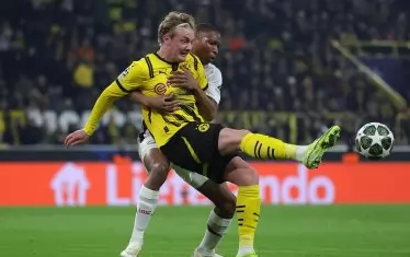 Защитникът на "Лил" Бафоде Диаките е прегърнал халфа на "Борусия" Юлиан Брант в закъснял опит да му попречи да отиграе топката.