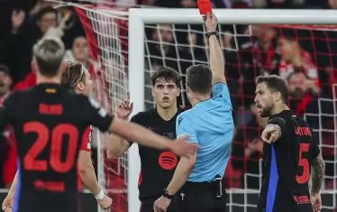 Защитникът на "Барселона" Пау Кубарси (в средата) получава червен картон от рефера Феликс Цвайер (в гръб) в 22-ата мин. на мача срещу "Бенфика" в Лисабон.
