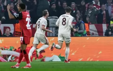 Голмайсторът на "Байерн" Хари Кейн (в средата) тича радостен, след като е открил резултата срещу "Байер" с първия от двата си гола на мача в Мюнхен.