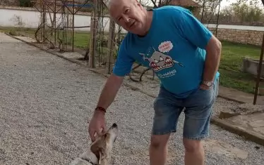 Шотландецът Саймън с куче и котка в двора си.