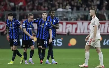 Футболистите на "Интер" се поздравяват след последния съдийски сигнал, докато английският бранител на "Байерн" Ерик Дайър напуска унил терена на "Алианц Арена".