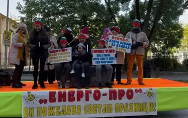 Коледен хор, който пее на свещи, защото няма ток, с ушанки, шалове, палта, защото умират от студ. Слогана на този сюжет е „Всичко, което искам за коледа е ток"