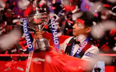 Китайският император на снукъра се възхищава на своя трофей, засипан от конфетите в шефидлския театър "Крусибъл".