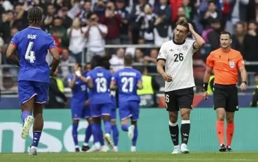 Футболистите на Франция (в синьо) се радват на втория си гол във вратата на Германия, а халфът на Бундестима Том Бишоф (в бяла фланелка) вече усеща накъде отиват нещата в мача за третото място в Щутгарт.