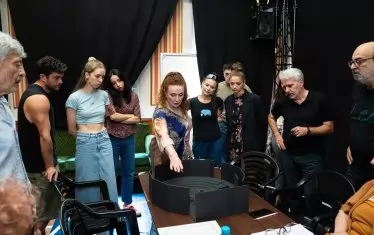 Режисьорката и сценографът Чавдар Гюзелев (с бялата коса вдясно) показват на артистите макет на сцената.