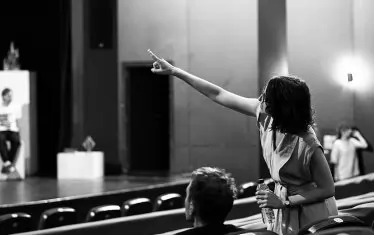 Режисьорката напътства актьорите в репетиционния процес.