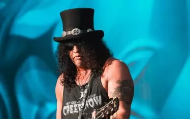 Слаш е звездата на вечерта, с неизменните къдрици и цилиндър.