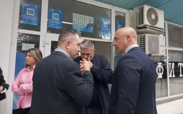 Срещата е свършила, депутати и кмет разпускат. От плакат на стената гледа Даниел Митов, част от листата през 2024 г. - ама не е сред хората, защото е министър, а Борисов му се сърди. 