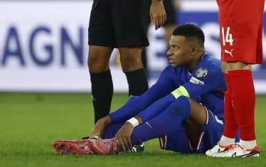 Капитанът на Франция Килиан Мбапе седи на терена и дава признаци, че не може да продължи домакинския мач срещу Азербайджан заради болка в десния глезен.