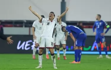 Албанският халф Юлян Шеху е разперил ръце покрай попарените сърби и се радва на победата с 1:0 в Лесковац.
