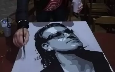  Художникът работи над портрета на Боно от U2.