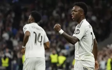 Бразилецът Винисиус (вдясно) ликува след гола на съотборника си Орелиен Чуамени (вляво), а по-късно самият той се разписа за успеха на "Реал" над "Бенфика" в Мадрид.