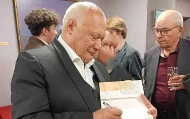 Писателят дава автограф върху новоизлезлия том.